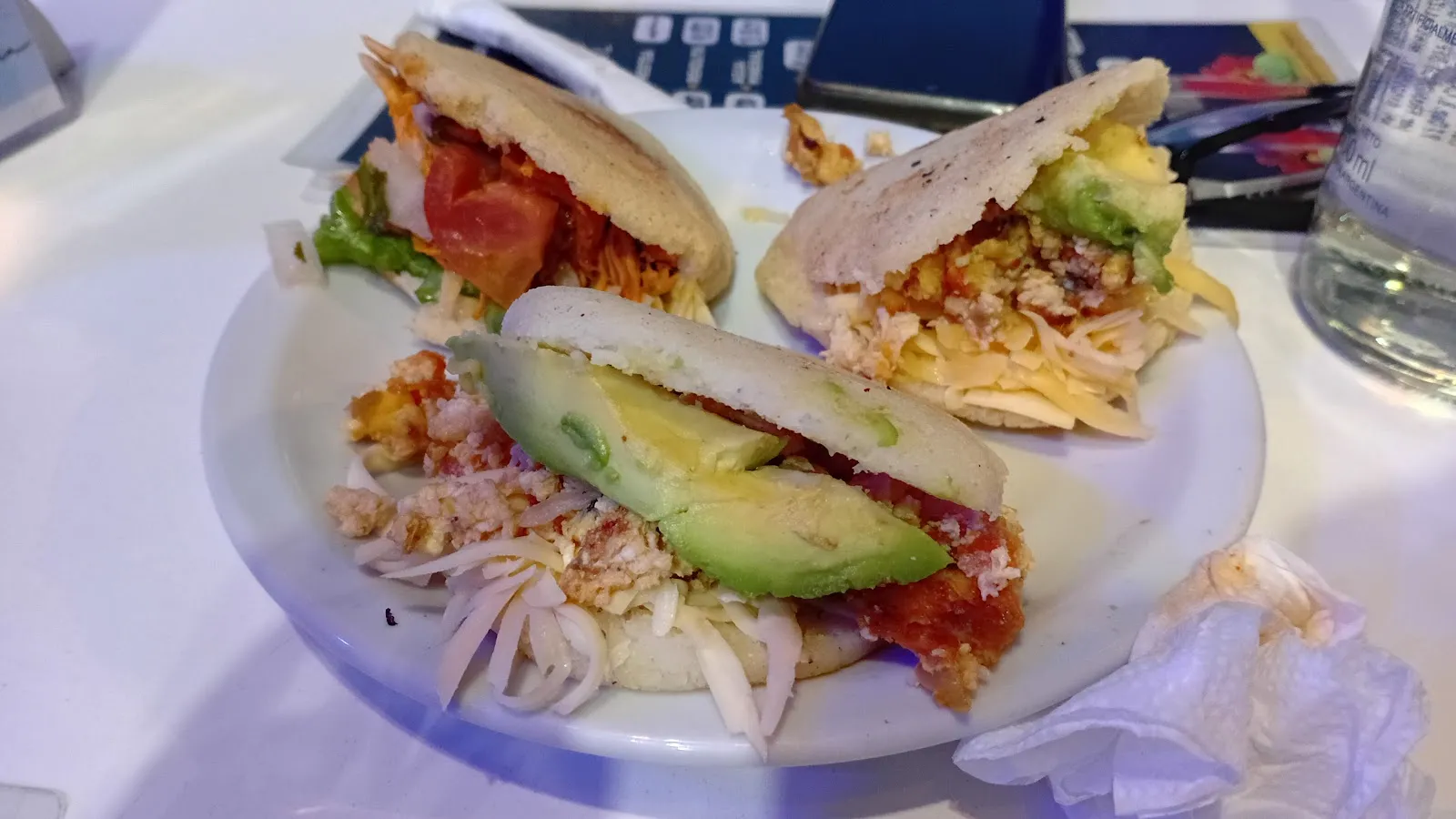 Arepas recién hechas rellenas de carne mechada, palta y tomate
